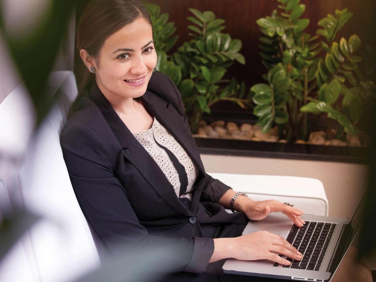 Movenpick Jumeirah Village Triangle ドバイ エクステリア 写真 A business woman working on a laptop